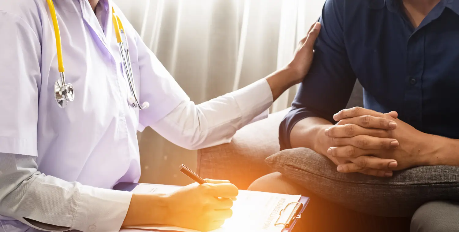 Der Physiater führt eine Konsultation mit dem stressgeplagten männlichen Patienten durch, schreibt auf einer Papierkarte den Behandlungsplan, verschwommenes Licht um ihn herum